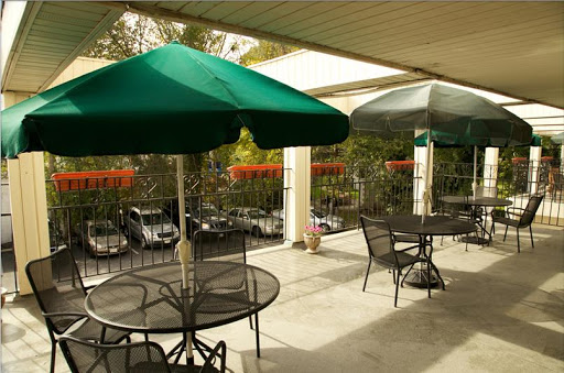 A cozy outdoor patio area with green umbrellas and tables, perfect for dining al fresco.