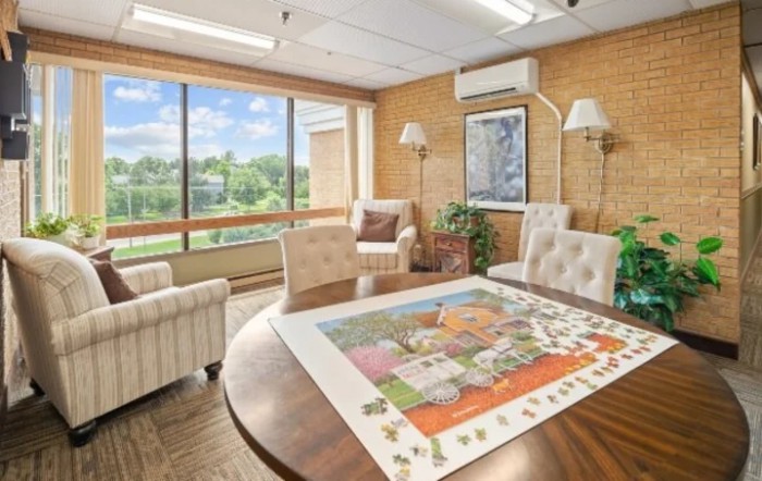 A cozy office space with comfortable seating and a large window providing natural light.