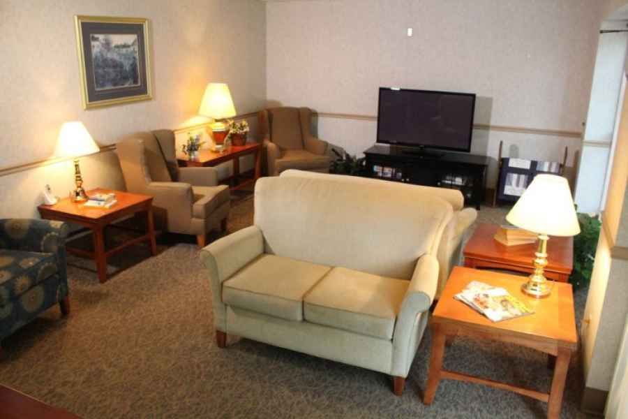 A cozy living room with a sofa, armchairs, and a TV.