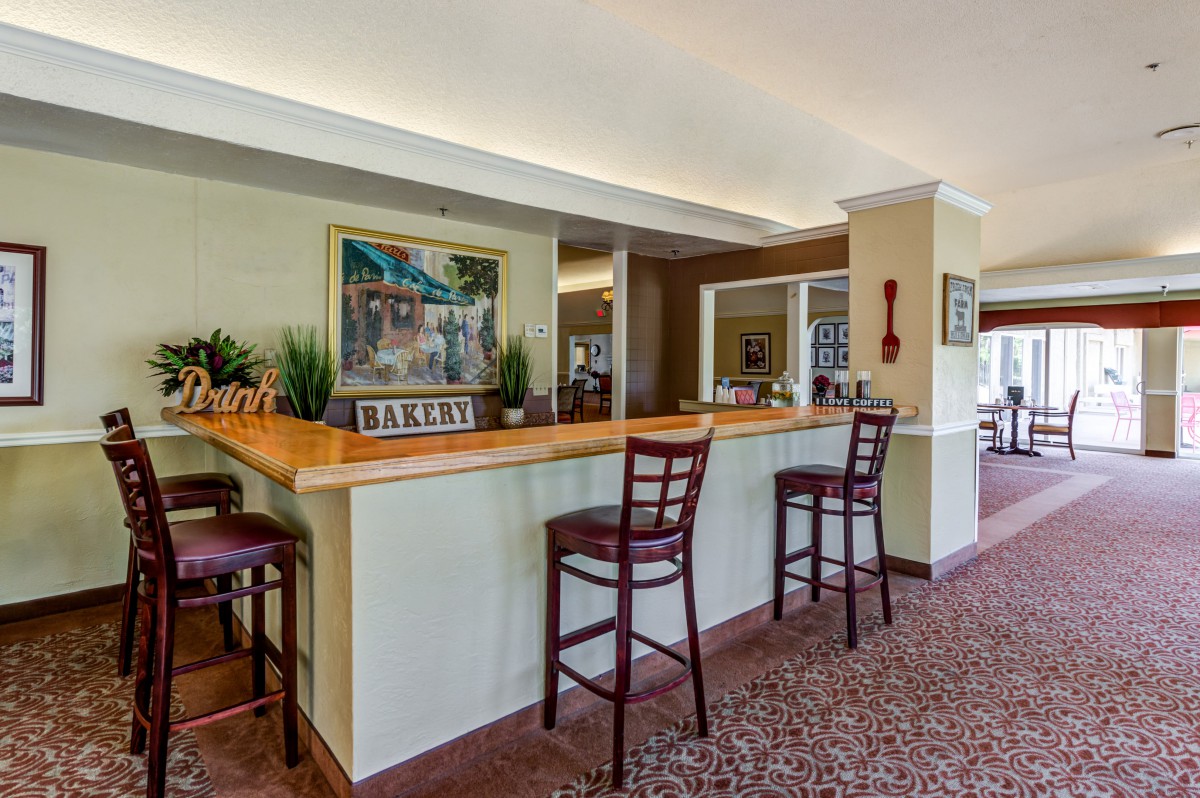 An interior view of a bar area with high chairs and decorative elements.