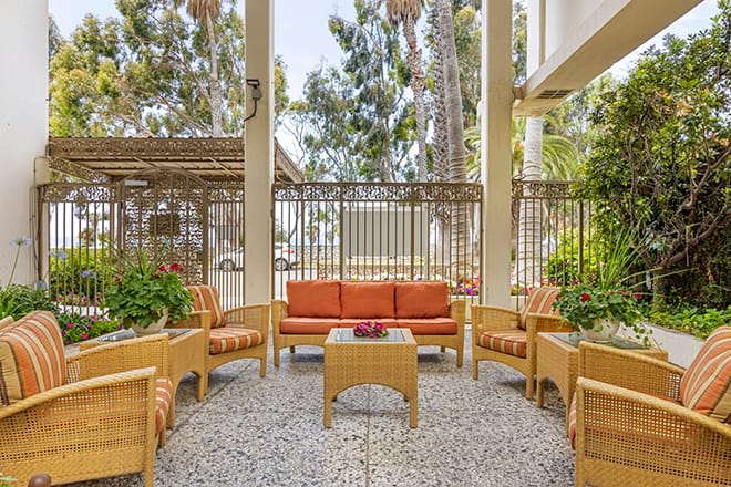 An inviting outdoor seating area with comfortable furniture and lush greenery.