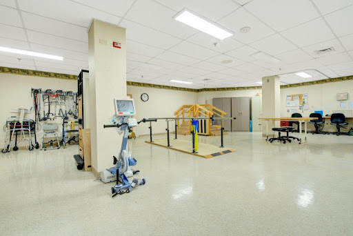 A spacious rehabilitation therapy room equipped with exercise machines and facilities for physical therapy.