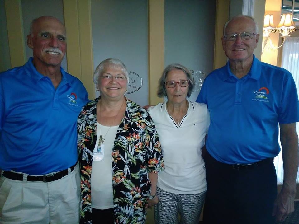 A group of four people smiling indoors.