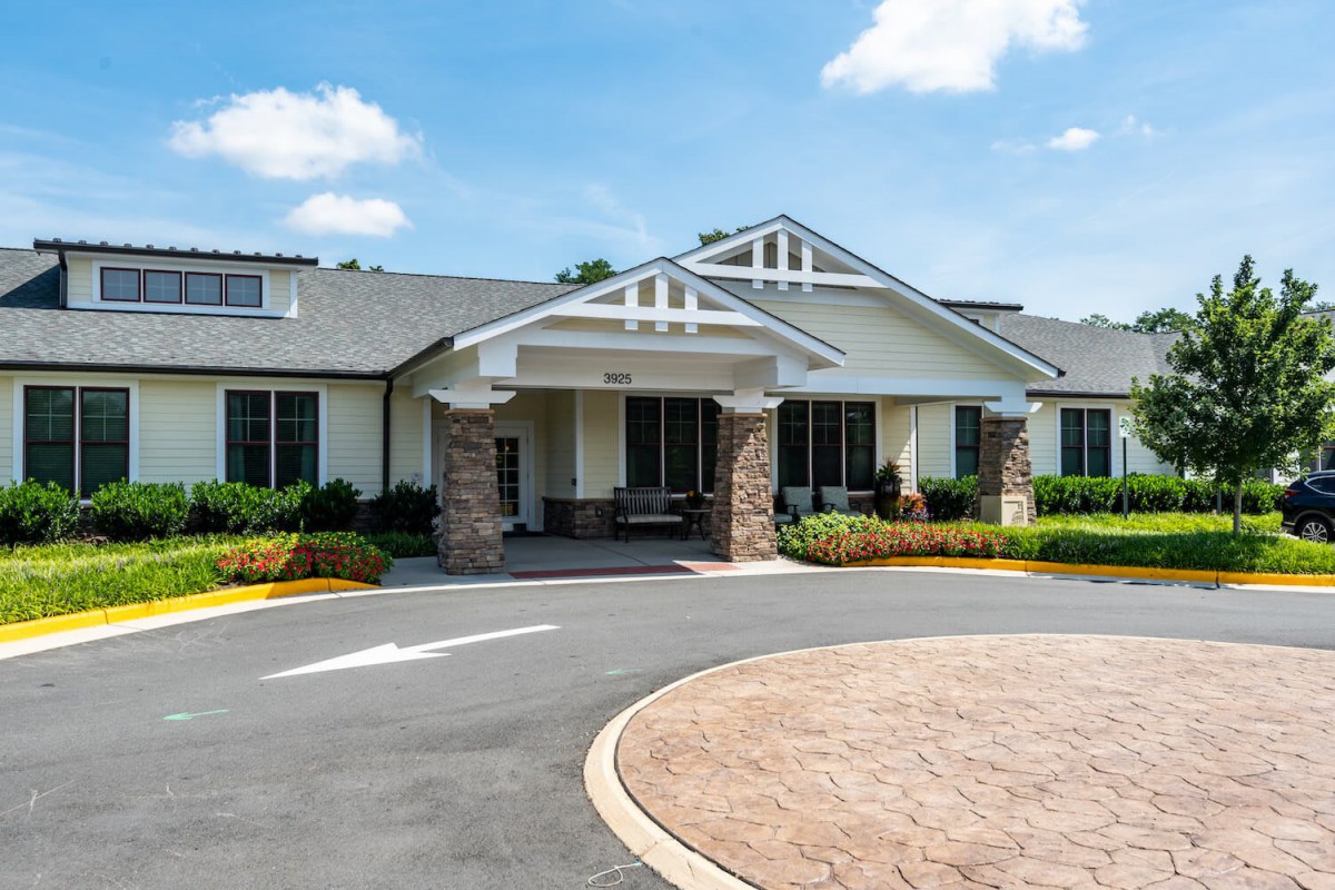 A modern building with a landscaped entrance and a circular driveway.