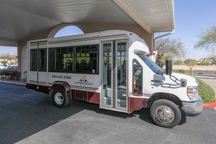 A shuttle bus parked under a covered area.