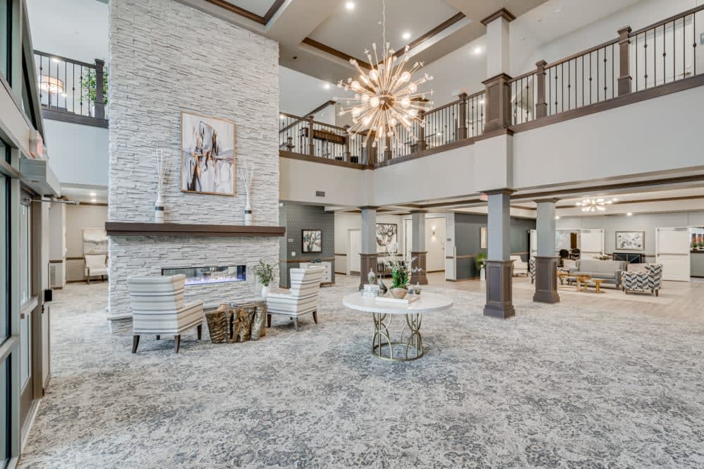A modern and spacious lobby area with a large chandelier, comfortable seating, and contemporary artwork.