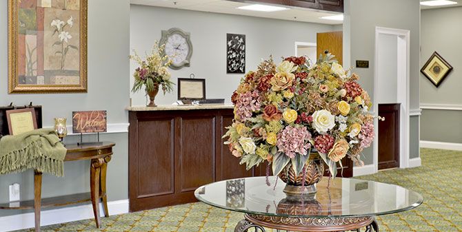A welcoming reception area with floral arrangements and a wooden desk.