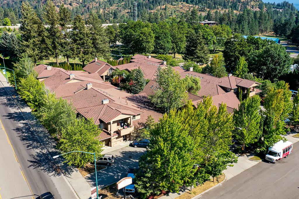 Aerial view of a building complex surrounded by trees and greenery.