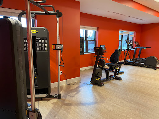 A well-equipped gym featuring various exercise machines in a vibrant setting.