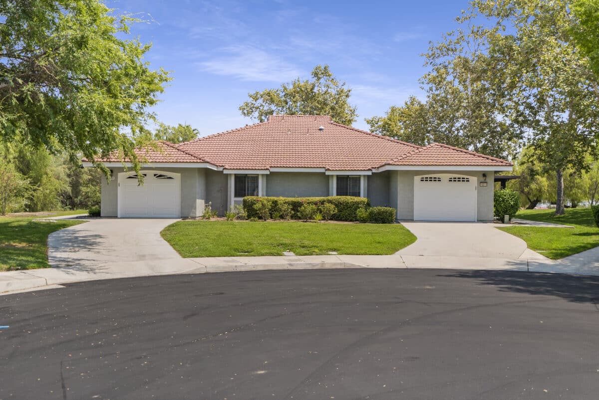 A suburban house with a well-maintained lawn and multiple garages.