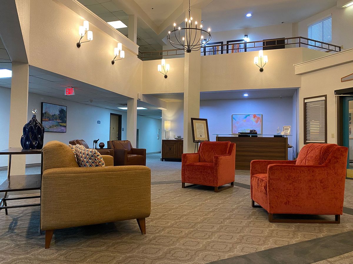 A spacious lobby area featuring modern armchairs and elegant lighting fixtures.