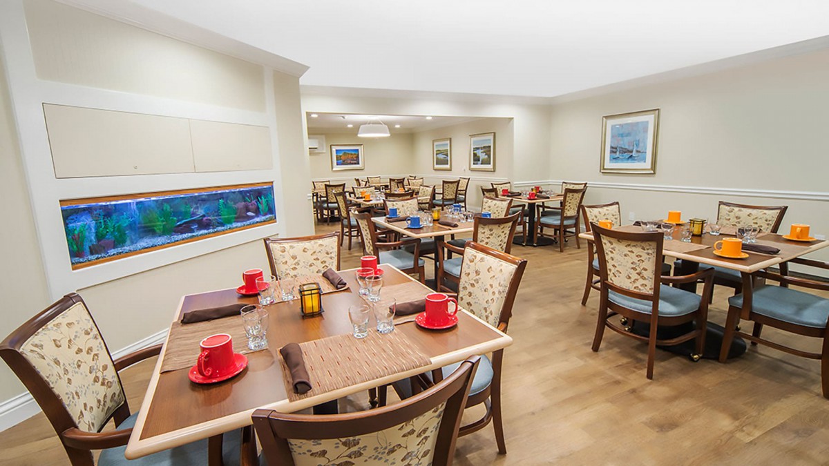 A cozy dining area with neatly set tables and comfortable chairs.