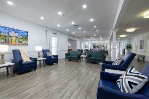 A spacious, modern lobby with comfortable armchairs and wood flooring.