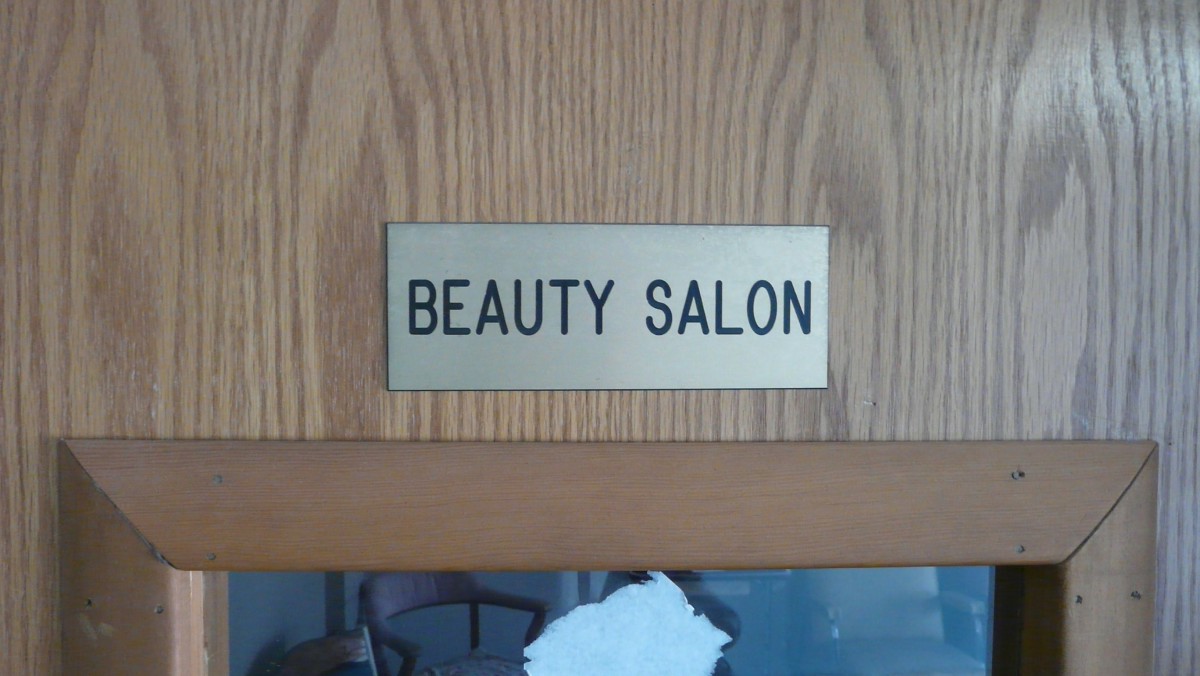 A plaque sign indicating a beauty salon on a wooden surface.