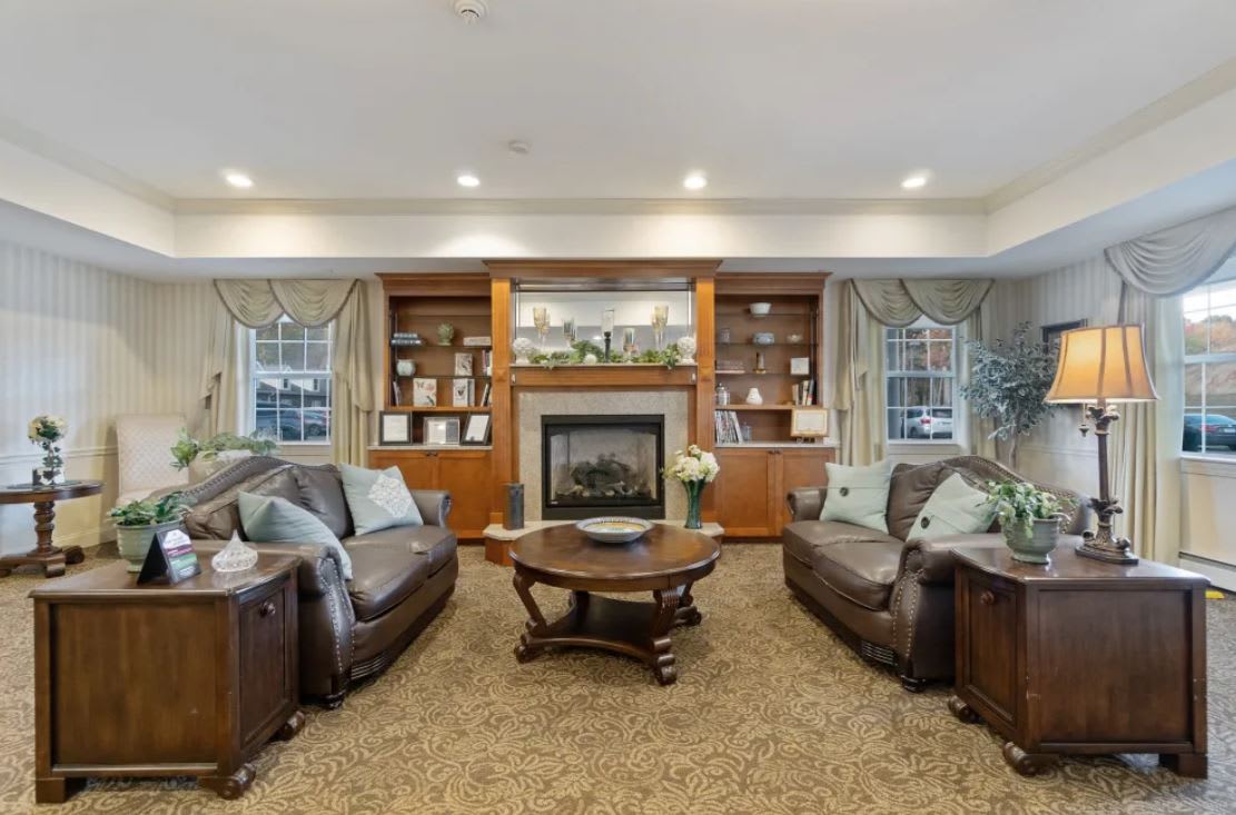 Cozy living room with leather sofas, a central fireplace, and built-in shelves.