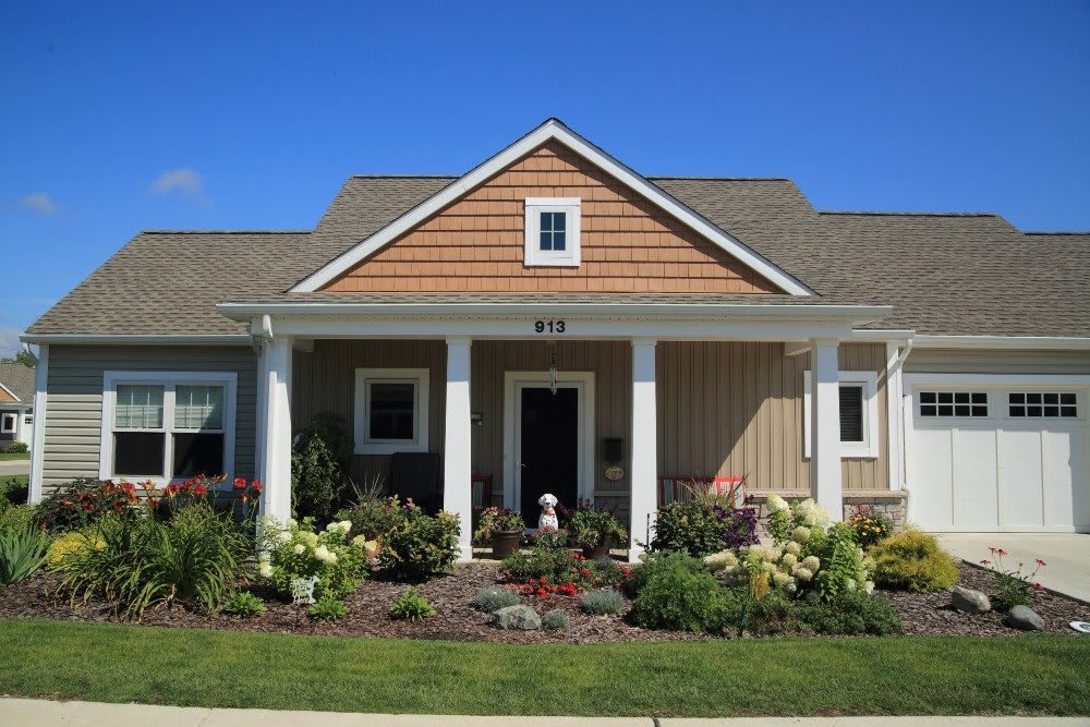 A charming single-story house with a well-maintained garden in the front yard.