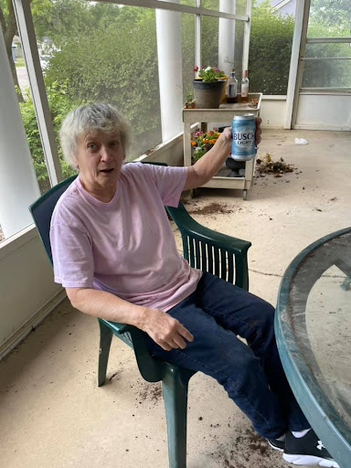 A woman sitting comfortably in a chair, enjoying a drink in an indoor setting.