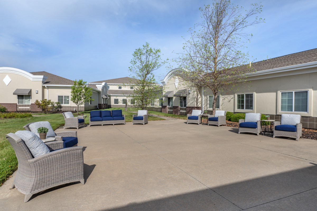 A spacious courtyard with comfortable patio seating and surrounding buildings.