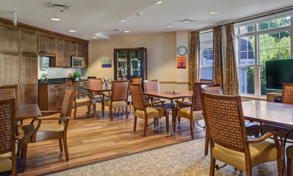 A comfortable dining area with wooden tables and chairs, set in a warmly decorated room.