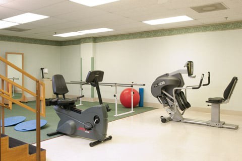 A rehabilitation room featuring stationary bikes and exercise equipment.