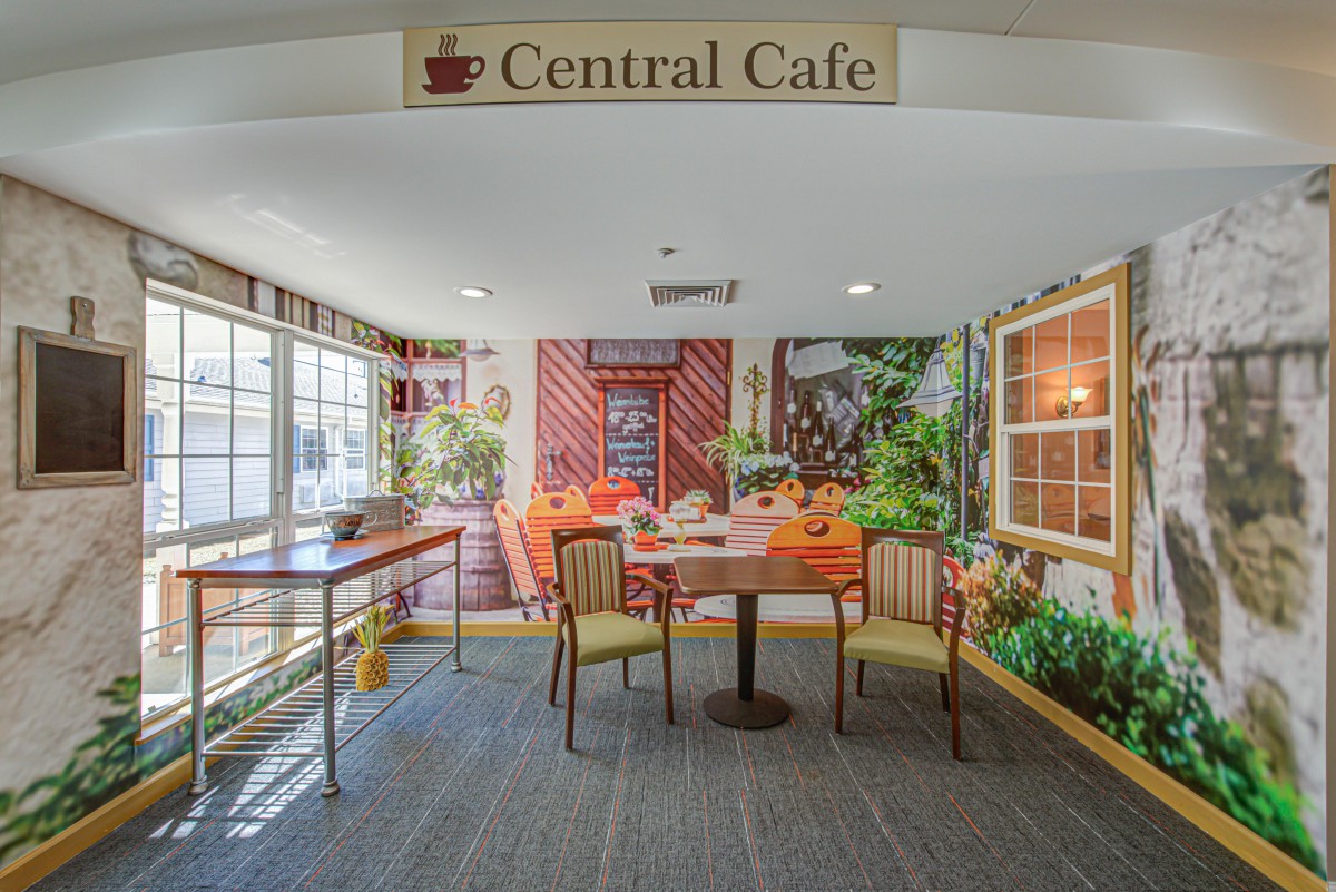 A cozy seating area inside the Central Cafe, featuring a table with chairs and lush decorations.