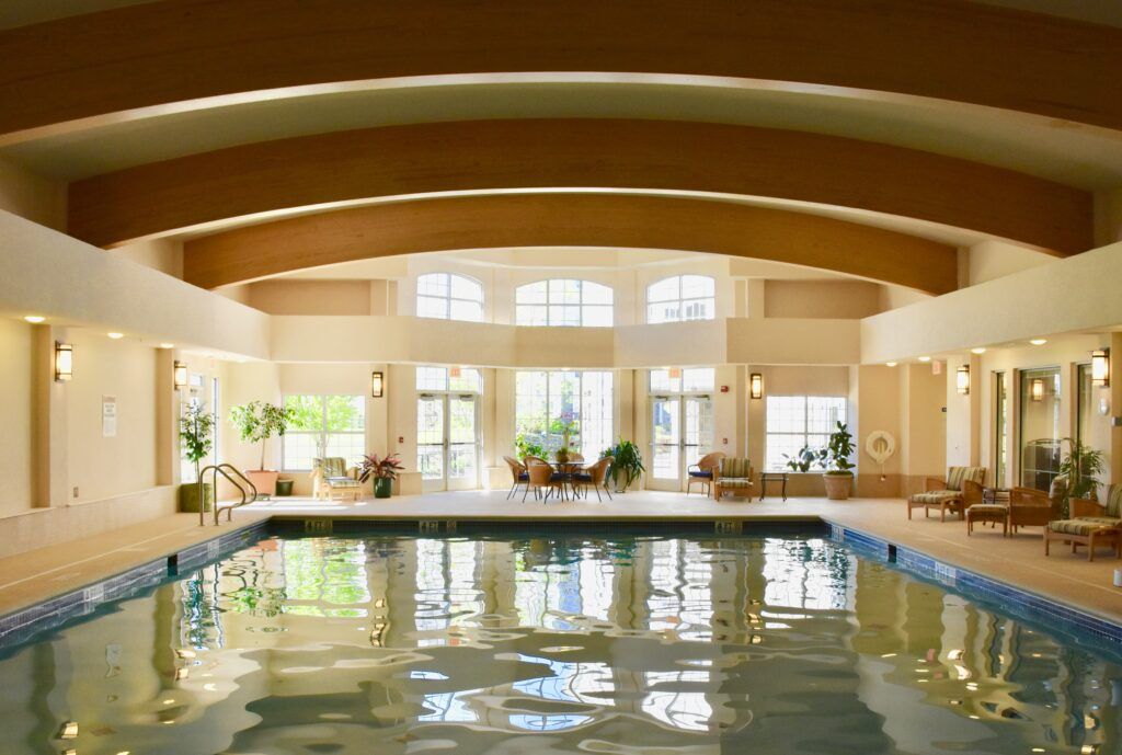 A spacious indoor swimming pool with ample natural light streaming through large windows.