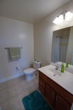 A minimalist bathroom featuring a sink, toilet, and towel.
