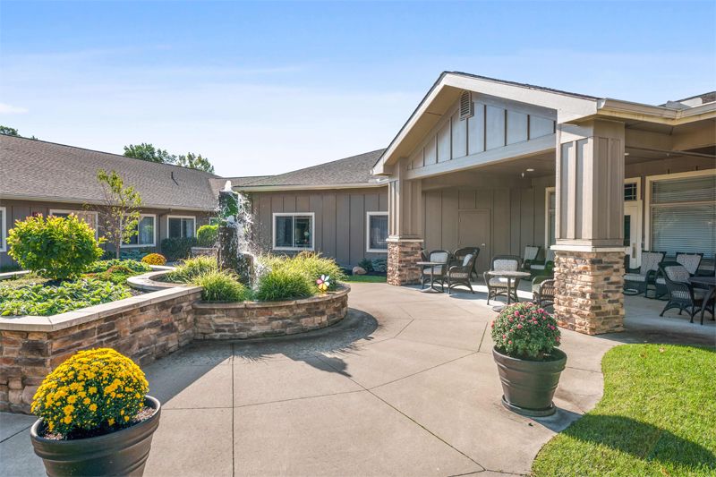 A scenic courtyard with outdoor seating, a fountain, and landscaped plants.