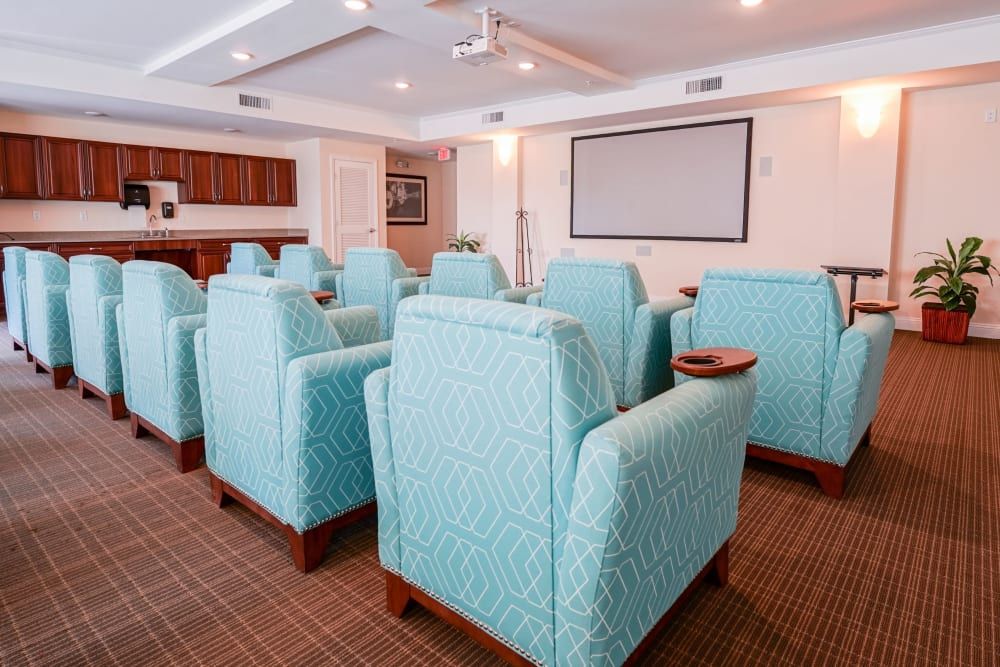 A cozy home theater room with comfortable armchairs facing a large projector screen.