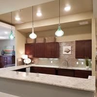 A modern kitchen with pendant lighting and a sleek countertop.