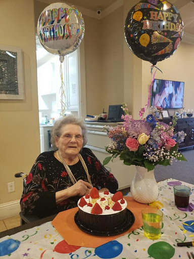 Celebrating a special birthday with cake, flowers, and balloons.