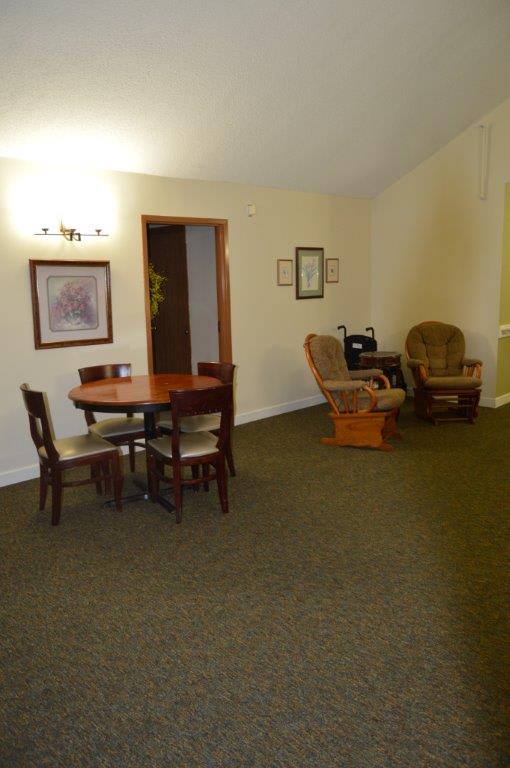 A cozy living and dining area with a round table and comfortable seating.