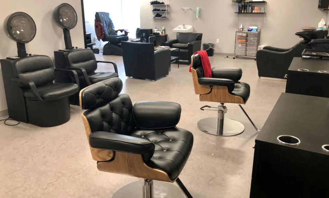 Modern barbershop interior with stylish chairs and equipment.