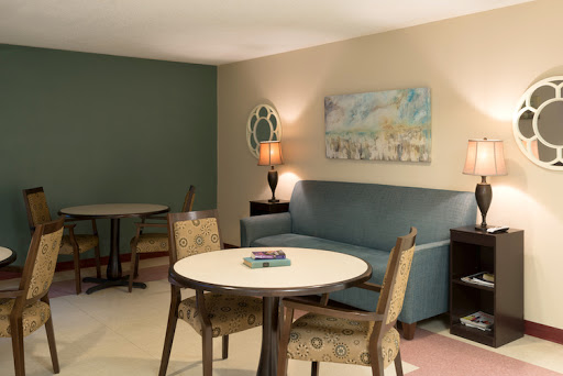 A cozy living area featuring a sofa, round table, and decorative artwork.