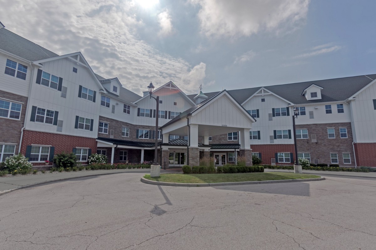 A large residential building with a traditional architectural style under a cloudy sky.
