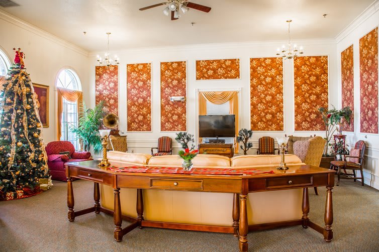 A well-decorated living room featuring a stylish sofa, ornate wallpaper, and elegant furniture.