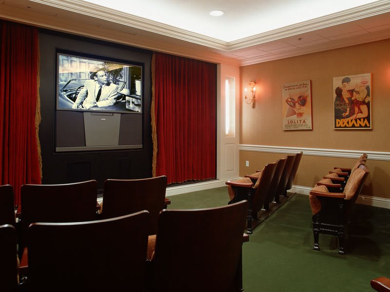 A cozy home theater room with a large screen and comfortable seating.