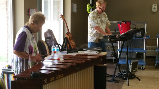 Two musicians performing together, one on a xylophone and the other playing a keyboard.
