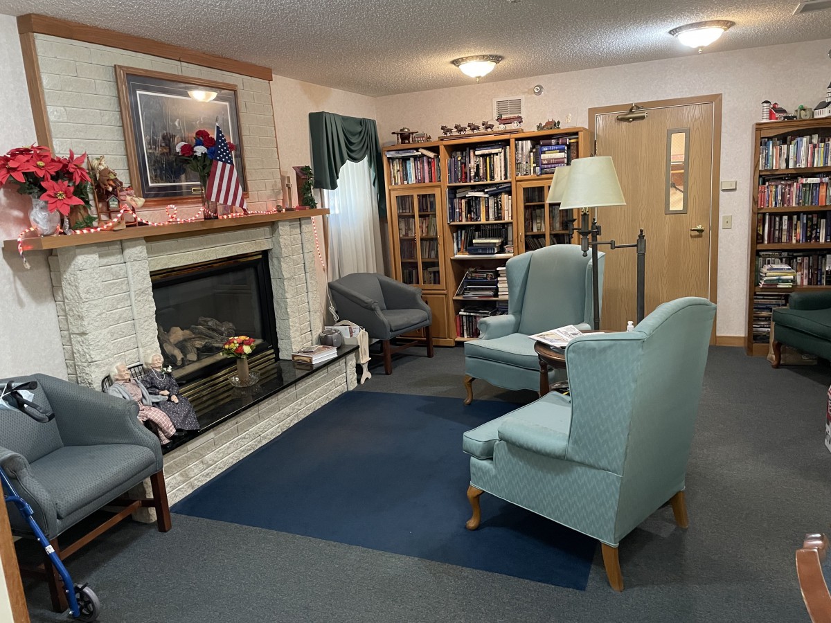 A cozy living room with a fireplace, bookshelves, and comfortable seating.