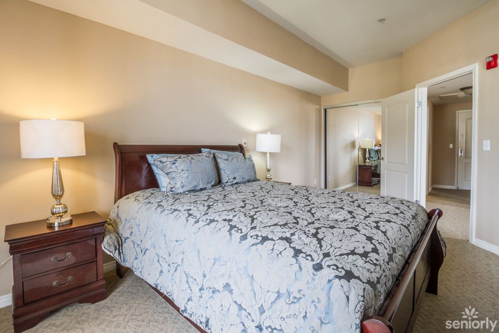 A cozy bedroom with a large bed and bedside lamps.