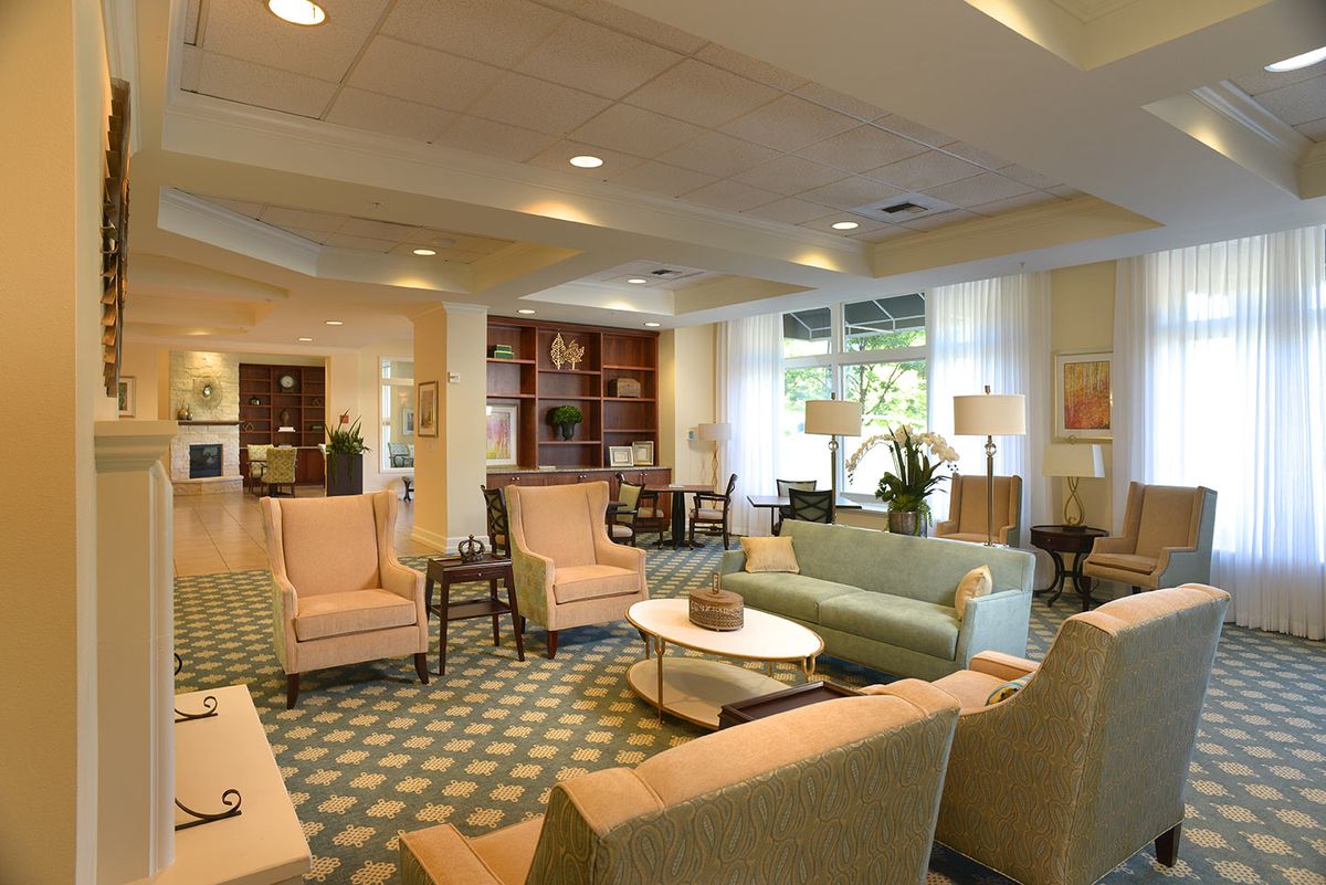 A spacious and elegantly decorated living room featuring comfortable seating and abundant natural light.