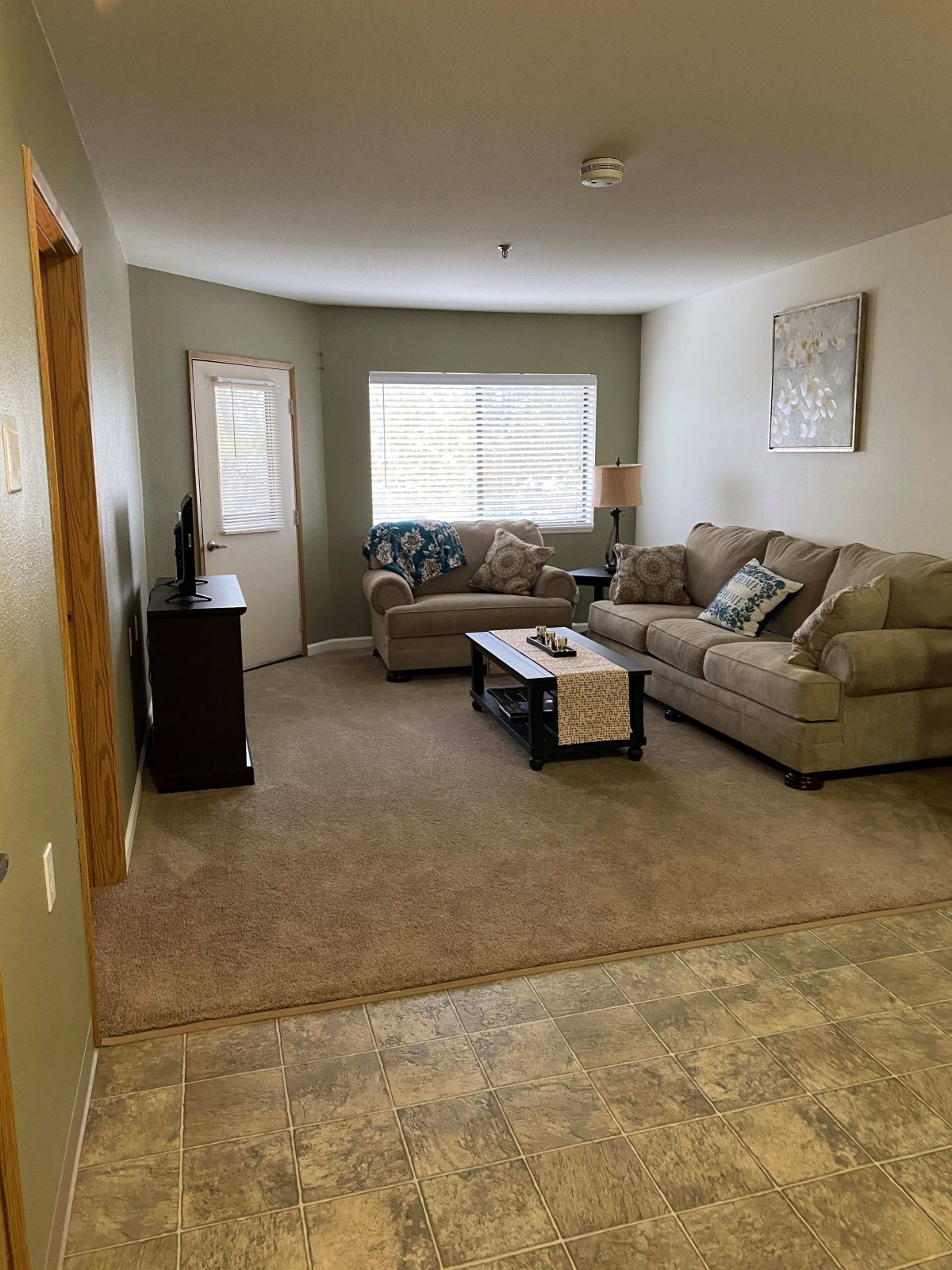 A cozy living room with a sofa set, coffee table, and television stand.