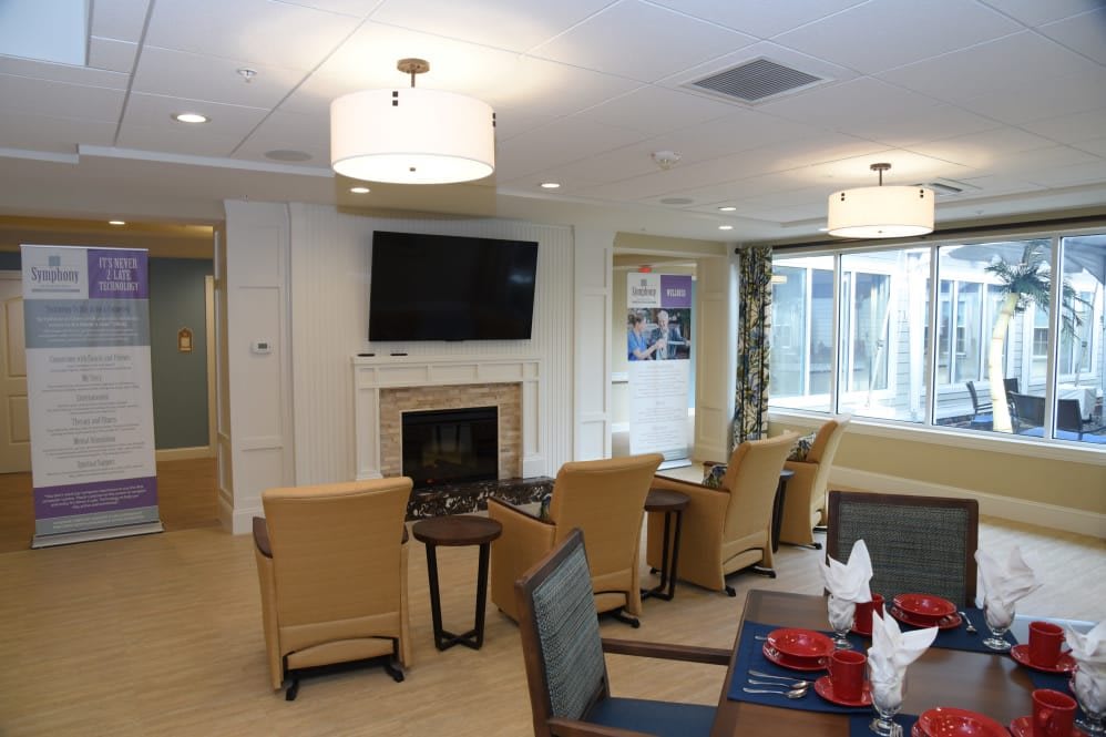 A cozy living room with comfortable seating, a fireplace, and a wall-mounted television.