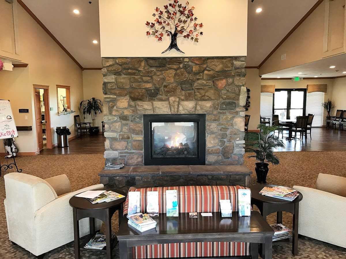 A cozy lobby with a stone fireplace and comfortable seating surrounded by decor and informational brochures.
