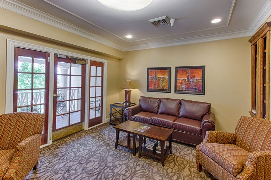 A cozy living room with a leather sofa, coffee table, and artwork on the wall.