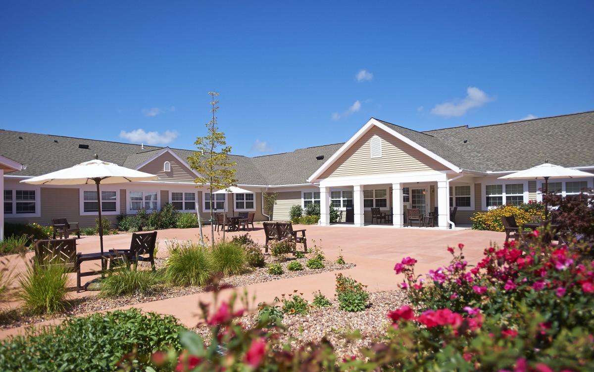 A scenic view of a building's exterior with a landscaped garden and clear blue sky.