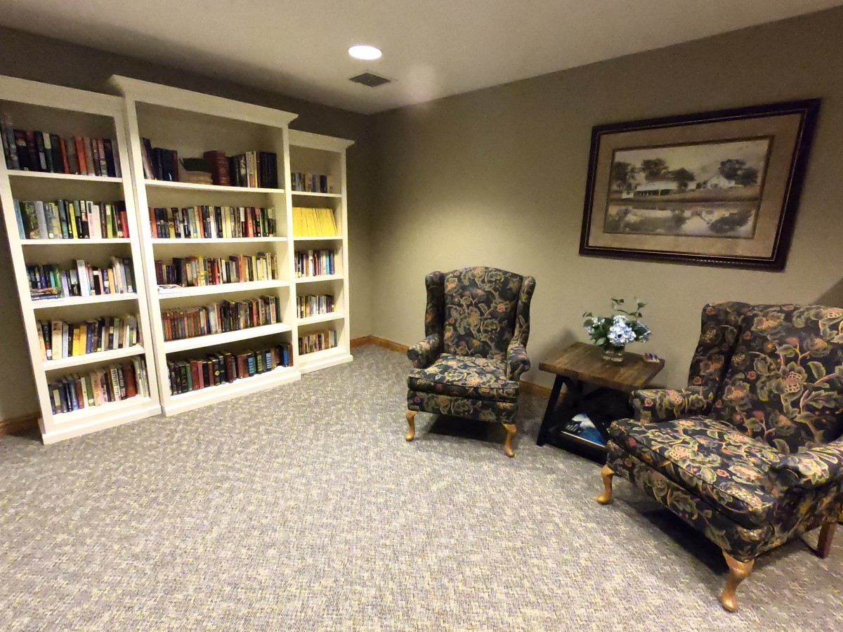 A cozy reading area with bookshelves and armchairs.