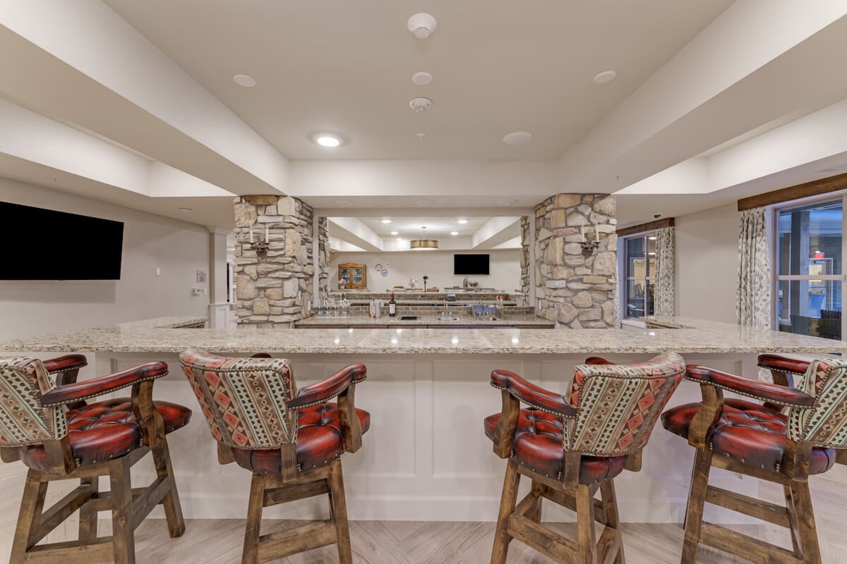 A modern bar interior with brick walls, a sleek counter, and stylish bar stools.