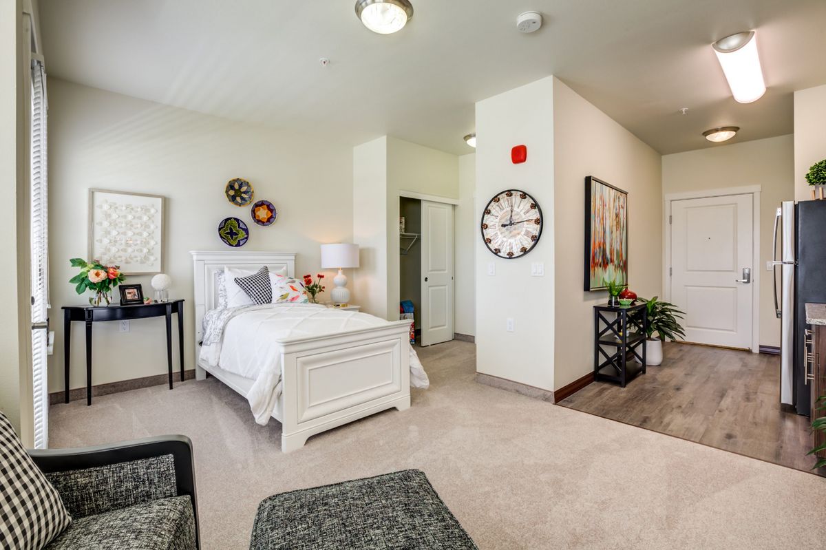 A modern bedroom with elegant decor and white furnishings.