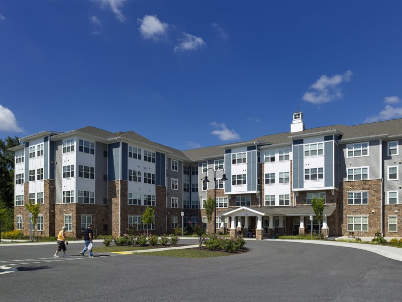 A modern residential apartment complex under a clear blue sky.